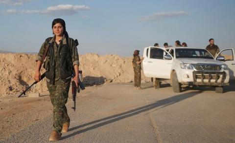 A female member of the Sinjar Resistance Units (YBS), a militia affiliated with the Kurdistan Workers' Party (PKK), carries a sniper and an AK-47 rifle in the village of Umm al-Dhiban, northern Iraq, April 29, 2016. PHOTO BY REUTERS/Goran Tomasevic