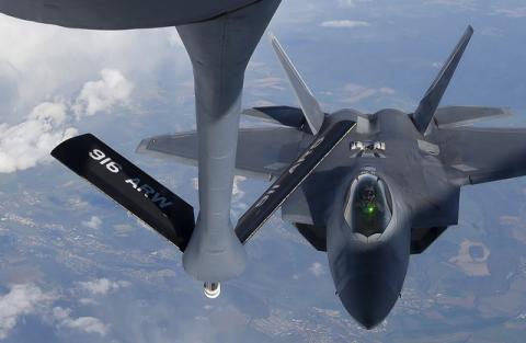 A pilot looks up from a U.S. F-22 Raptor fighter at a fuel boom as it prepares to refuel in mid-air with a KC-135 plane over European airspace during a flight to Britain from Mihail Kogalniceanu air base in Romania, April 25, 2016. PHOTO BY REUTERS/Toby Melville