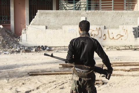 A Free Syrian Army fighter carries his weapon on one of the battlefronts in Jobar, a suburb of Damascus