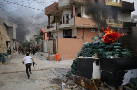 A Kurdish gunman runs across a street in Tuz Khurmato during clashes between Shi'ite militia and Kurdish gunmen, Iraq, April 24, 2016. PHOTO BY REUTERS/Goran Tomasevic