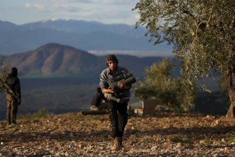 A Turkish-backed Free Syrian Army fighter carries a military binoculars north of the city of Afrin, Syria, February 18, 2018. PHOTO BY REUTERS/Khalil Ashawi