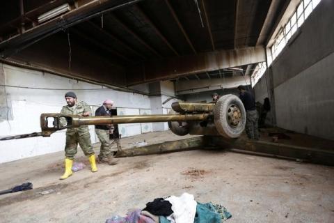 Rebel fighter clean a weapon in al-Rai town, northern Aleppo countryside, Syria, December 25, 2016. PHOTO BY REUTERS/Khalil Ashawi