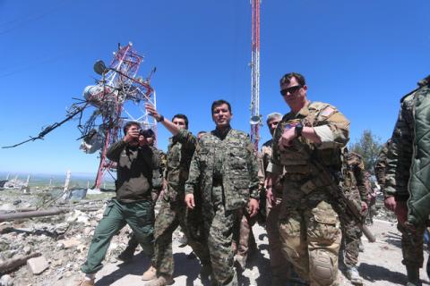 A U.S. military commander (R) walks with a commander (C) from the Kurdish People's Protection Units (YPG) as they inspect the damage at YPG headquarters after it was hit by Turkish airstrikes in Mount Karachok near Malikiya, Syria. PHOTO BY REUTERS/Rodi Said