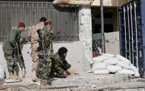 Members of the Libyan pro-government forces, backed by locals, take up positions during clashes with the Shura Council of Libyan Revolutionaries. PHOTO BY REUTERS/Esam Omran Al-Fetori