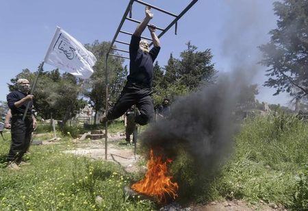 Rebel fighters from 'the First Regiment', part of the Free Syrian Army, swing from bars as they participate in a military training in the western countryside of Aleppo, May 4, 2015. PHOTO BY REUTERS/Hosam Katan