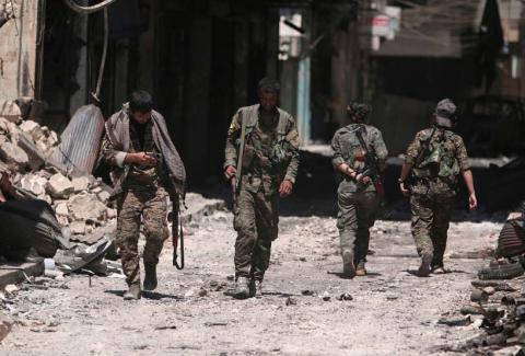 Syria Democratic Forces (SDF) fighters walk on the rubble of damaged shops and buildings in the city of Manbij, in Aleppo Governorate, Syria, August 10, 2016. PHOTO BY REUTERS/Rodi Said