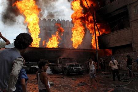 People look at a burning fuel truck after it was set ablaze during clashes between Houthis and fighters of the Popular Resistance Committees in Taiz, Yemen, May 25, 2015. PHOTO BY REUTERS/Stringer