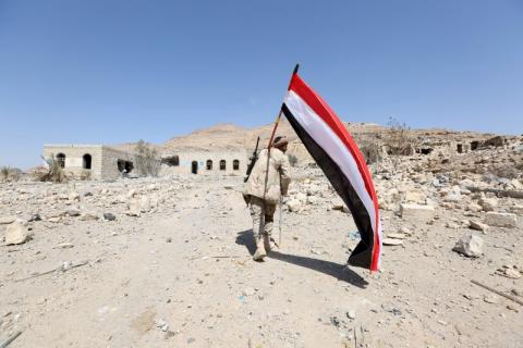 A pro-government army soldier carries Yemen's national flag as he walks at the strategic Fardhat Nahm military camp, around 60km (40 miles) from Yemen's capital Sanaa, February 11, 2016. PHOTO BY REUTERS/Ali Owidha