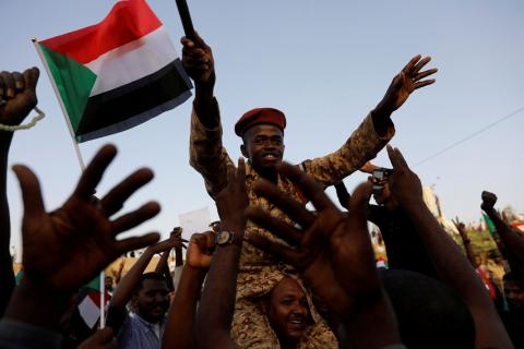 A Sudanese soldier sits on the shoulders of a demonstrator, cheering with the crowd outside Defence Ministry in Khartoum, Sudan, April 16, 2019. PHOTO BY REUTERS/Umit Bektas