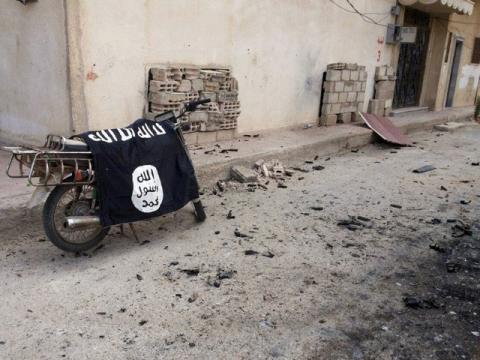 A flag belonging to the Islamic State fighters on a motorbike after forces loyal to Syria's President Bashar al-Assad recaptured the historic city of Palmyra, in Homs Governorate, March 27, 2016. PHOTO BY REUTERS/SANA