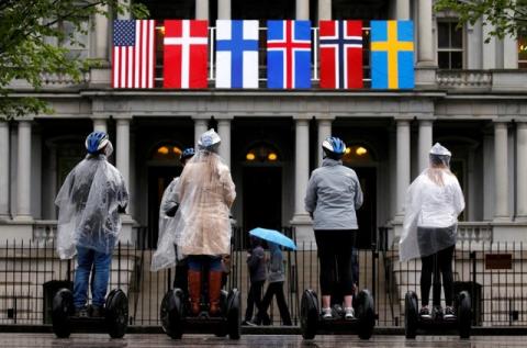 A segway tour stops in front of flags of the Nordic nations hanging from the Eisenhower Executive Office Building beside the White House in Washington, May 11, 2016. PHOTO BY REUTERS/Kevin Lamarque