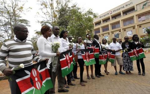 Survivors and relatives of victims carry Kenyan national flags as they attend the first anniversary memorial service of the Westgate shopping mall terrorist attack in Kenya's capital Nairobi, September 21, 2014. PHOTO BY REUTERS/Thomas Mukoya