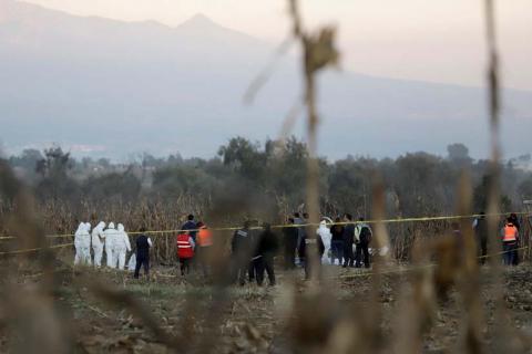 Forensic technicians and rescue personnel stand at the scene where the helicopter transporting Martha Erika Alonso, governor of the state of Puebla, and his husband Senator Rafel Moreno Valle crashed, in Coronango, Puebla Mexico, December 24, 2018. PHOTO BY REUTERS/Imelda Medina