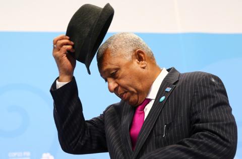 Frank Bainimarama, Prime Minister of Fiji and president of the COP23, takes off his hat at the start of the final session of the U.N. Climate Change Conference 2017 hosted by Fiji but held in Bonn, Germany, November 18, 2017. PHOTO BY REUTERS/Wolfgang Rattay
