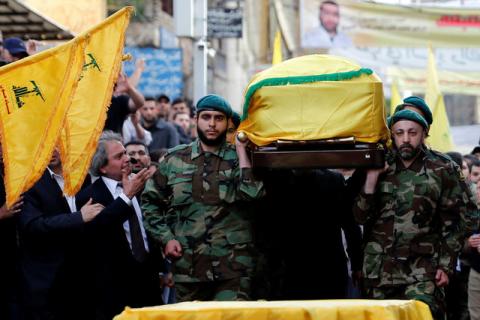 Hezbollah members carry the coffin of top Hezbollah commander Mustafa Badreddine, who was killed in an attack in Syria, as his brother mourns his death during his funeral in Beirut's southern suburbs, Lebanon, May 13, 2016. PHOTO BY REUTERS/Jamal Saidi