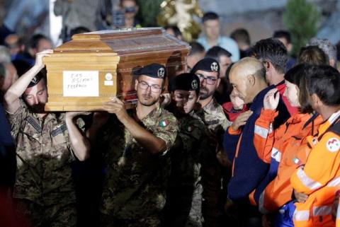 Italian soldiers carry a coffin at the end of funeral service for victims of the earthquake that levelled the town in Amatrice, central Italy, August 30, 2016. PHOTO BY REUTERS/Max Rossi