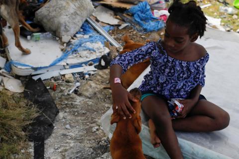 A girl pets her dog after Hurricane Dorian hit the Abaco Islands in Spring City, Bahamas, September 11, 2019. PHOTO BY REUTERS/Marco Bello