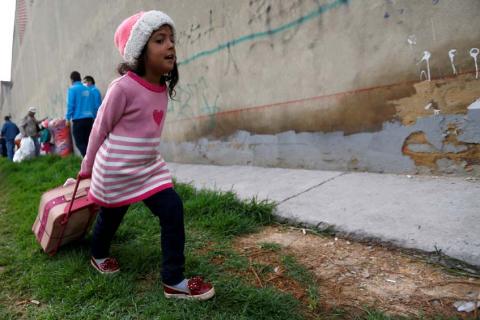 A Venezuelan migrant girl heads to the exit of a makeshift camp with her belongings in Bogota, Colombia, November 13, 2018. PHOTO BY REUTERS/Luisa Gonzalez
