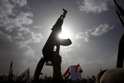 A Houthi follower rises a weapon as he attends a rally marking one year of Saudi-led air strikes, in Yemen's capital Sanaa, March 26, 2016. PHOTO BY REUTERS/Mohamed al-Sayaghi