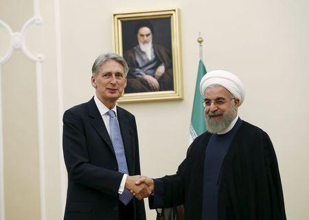Britain's Foreign Secretary Philip Hammond (L) shakes hands with Iran's President Hassan Rouhani before a meeting at the President's Palace in Tehran, Iran, August 24, 2015. PHOTO BY REUTERS/Darren Staples