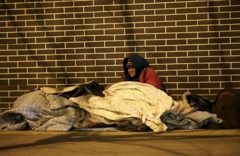 A homeless woman is seen on a cold winter night near Beijing South Railway Station in Beijing, China, January 23, 2016. PHOTO BY REUTERS/Jason Lee
