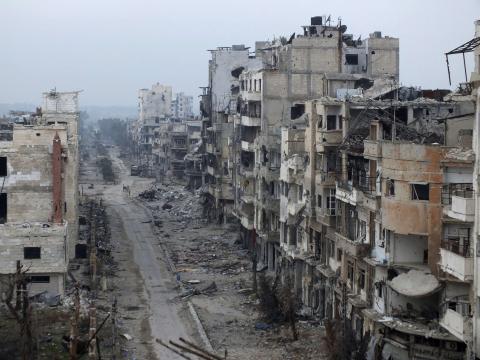 Damaged buildings line a street in the besieged area of Homs
