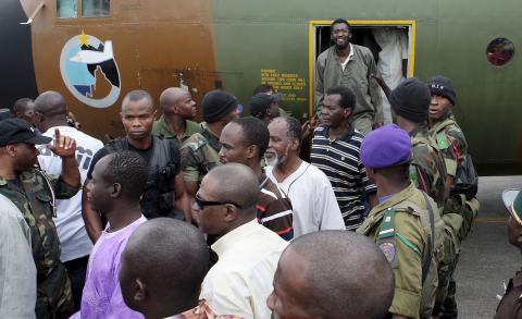 Cameroonian military personnel watch as freed hostages disembark from a military plane upon arriving at the Nsimalen International Airport in Yaounde, November 26, 2014. PHOTO BY REUTERS/Stringer