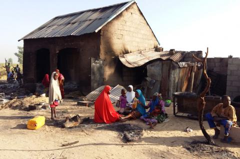 People sit near a burnt house after an attack by suspected members of the Islamist Boko Haram insurgency in Bulabulin village, Nigeria, November 1, 2018. PHOTO BY REUTERS/Kolawole Adewale