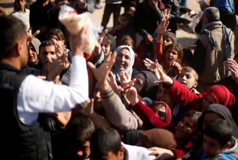 Displaced Iraqis, who fled the Islamic State stronghold of Mosul, gather to receive food supplies in a distribution point at Khazer camp, Iraq, November 23, 2016. PHOTO BY REUTERS/Mohammed Salem
