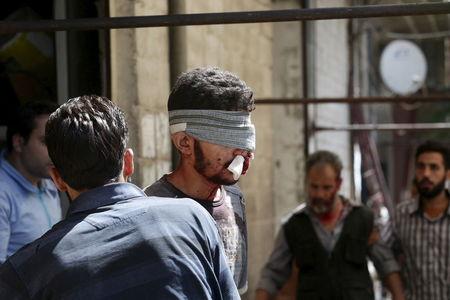 An injured man walks outside a field hospital after what activists said were air strikes by forces loyal to Syria's President Bashar al-Assad in the Douma neighborhood of Damascus, Syria, August 20, 2015. PHOTO BY REUTERS/Bassam Khabieh