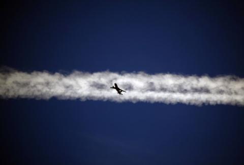 An aeroplane flies underneath the jet stream of another aircraft above the Italian city of Padova, September 18, 2013. PHOTO BY REUTERS/David Gray
