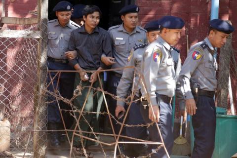 Detained Reuters journalist Kyaw Soe Oo is escorted by police for a court hearing in Yangon, Myanmar, January 23, 2018. PHOTO BY REUTERS/Stringer