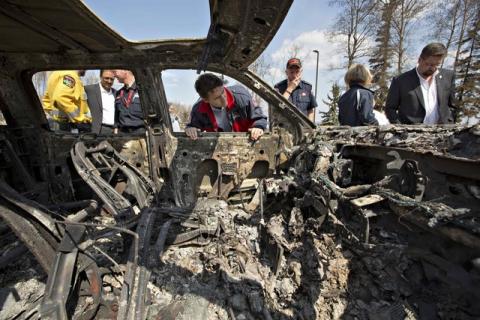 Canadian Prime Minister Justin Trudeau looks into a burnt out car while visiting neighborhoods devastated by the wildfire that forced the evacuation of the city in Fort McMurray, Alberta, Canada, May 13, 2016. PHOTO BY REUTERS/Jason Franson