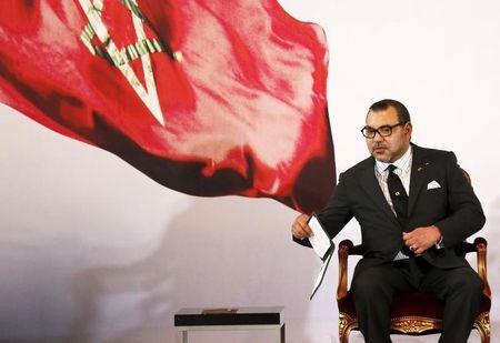 Morocco's King Mohammed VI holds a book during a visit, at the presidential palace in Abidjan, June 2, 2015. PHOTO BY REUTERS/Thierry Gouegnon