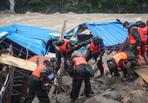 Paramilitary policemen search for missing people at the site of a landslide in Sanming, Fujian province, China, May 8, 2016. PHOTO BY REUTERS/China Daily