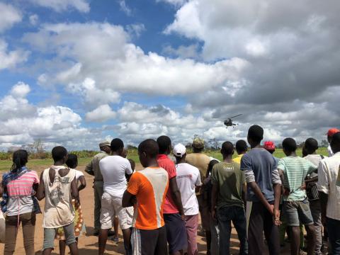 Locals watch as a helicopter lands in Guara Guara after Cyclone Idai outside Beira, Mozambique, March 22, 2019. PHOTO BY REUTERS/Emma Rumney