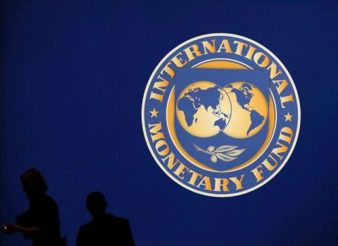 Visitors are silhouetted against the logo of the International Monetary Fund at the main venue for the IMF and World Bank annual meeting in Tokyo. PHOTO BY REUTERS/Kim Kyung-Hoon