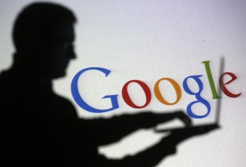 People are silhouetted as they pose with laptops in front of a screen projected with a Google logo, in this picture illustration taken in Zenica, October 29, 2014. PHOTO BY REUTERS/Dado Ruvic