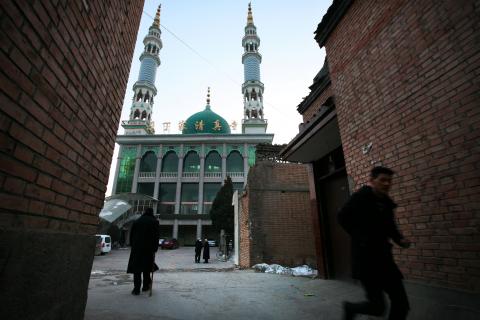 A man runs in front of a mosque at dusk as evening prayers are underway inside, in China's Linxia, Gansu province, home to a large population of ethnic minority Hui Muslims, February 2, 2018. PHOTO BY REUTERS/Michael Martina