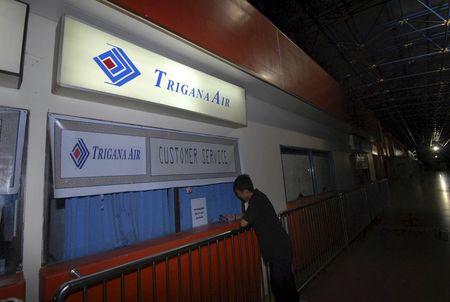 A man stands in front of the closed customer service counter of Trigana Air at Sentani Airport, near Jayapura, Papua province, August 16, 2015 in this photo taken by Antara Foto. PHOTO BY REUTERS/Lucky R