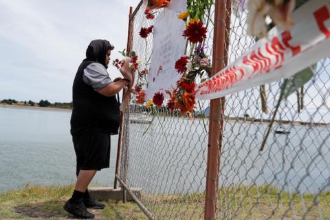 A man offers flowers at a memorial at the harbour in Whakatane, following the White Island volcano eruption in New Zealand, December 11, 2019. PHOTO BY REUTERS/Jorge Silva