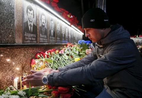 A man lights a candle at a memorial, dedicated to firefighters and workers who died after the Chernobyl nuclear disaster, during a night service in the city of Slavutych, Ukraine, April 26, 2016. PHOTO BY REUTERS/Gleb Garanich
