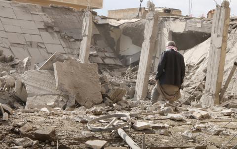 A man makes his way through rubble at a site hit by what activists said were airstrikes by forces loyal to Syria's President Bashar al-Assad in Raqqa, eastern Syria, which is controlled by the Islamic State, November 27, 2014. PHOTO BY REUTERS/Nour Fourat