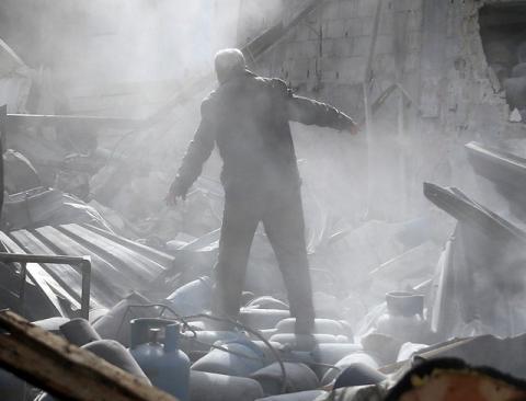 A man stands on the rubble of damaged buildings after an airstrike on the rebel-held town of Mesraba in the eastern Damascus suburb of Ghouta, Syria, November 26, 2017. PHOTO BY REUTERS/Bassam Khabieh