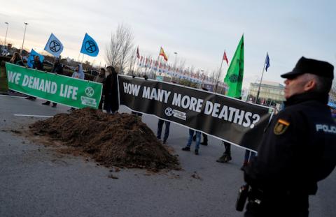 Climate change activists of Extinction Rebellion hold banners after unloading a truck filled with horse excrements in front of U.N. Climate Change Conference (COP25) in Madrid, Spain, December 14, 2019. PHOTO BY REUTERS/Nacho Doce