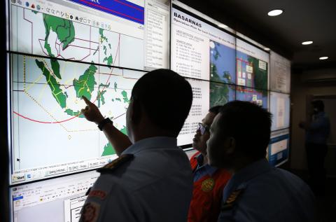 Military and rescue authorities monitor progress in the search for AirAsia Flight QZ8501 in the Mission Control Center inside the National Search and Rescue Agency in Jakarta, December 29, 2014. PHOTO BY REUTERS/Darren Whiteside