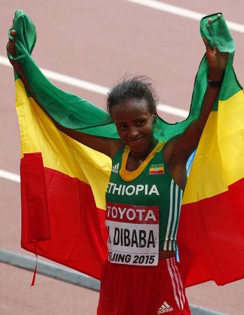 Mare Dibaba of Ethiopia holds her national flag after winning the women's marathon at the 15th IAAF Championships at the National Stadium in Beijing, China, August 30, 2015. PHOTO BY REUTERS/David Gray