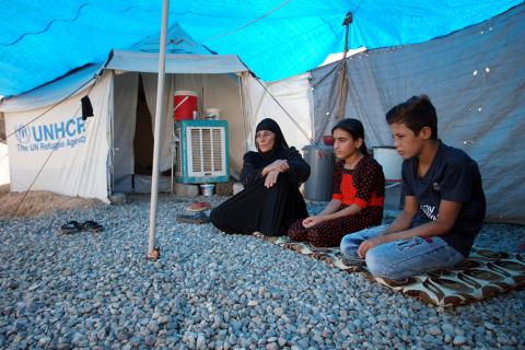 Mariam (Om Salih), a displaced Iraqi woman, who returns to camp after trying to go home and find the conditions in their towns unbearable, with lack of services and destroyed buildings, sits with her sons outside their tent at Hassan Sham camp, east of Mosul, Iraq, July 29, 2019. PHOTO BY REUTERS/Abdullah Rashid
