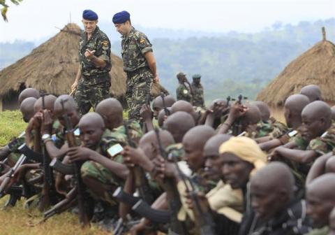 Members of the European Union Training Mission (EUTM) team (blue berets) walk past Somali government soldiers trained by the team
