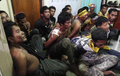 Members of the Muslim rebels of Moro National Liberation Front (MNLF), who surrendered to the government soldiers, wait to be fingerprinted at a police station in Zamboanga city